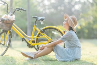 自転車の横で座る女性