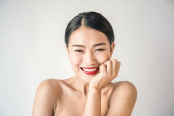 あごに手を置き笑顔の女性