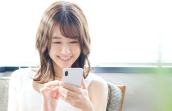 笑顔でスマホを操作する女性