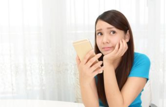 悲壮感ただよう表情でスマホを操作する女性