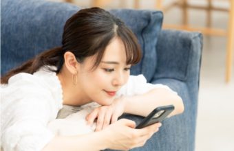 固い表情でスマホを見つめる女性