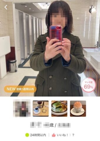 トイレの鏡で婚活アプリに載せる写真を撮影する女性